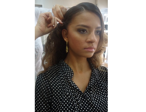 Divida o cabelo para o lado de sua preferência e aplique um spray fixador. Pegue uma mecha lateral e comece a enrolar.<br> Divida o cabelo para o lado de sua preferência e aplique um spray fixador. Pegue uma mecha lateral e comece a enrolar.<br>