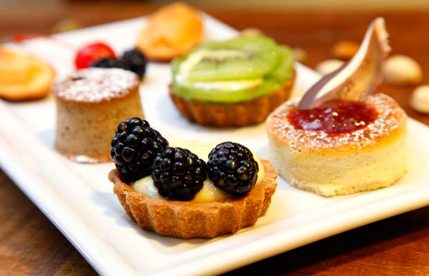 Gateau de voyage: duas madeleines ao mel, um mini savarin de pistache e amêndoas, um mini bolo de banana com nozes e uma mini tartalette de creme patissier e frutas<br>