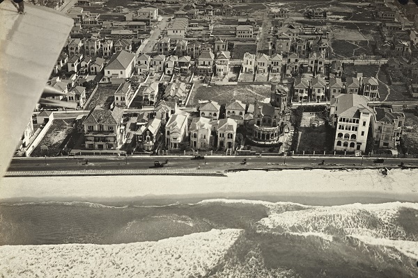 Leme, por José Augusto de Paiva Meira (c. 1921). Piloto de hidroaviões da Marinha, o fotógrafo produziu diversas imagens aéreas da cidade. Detalhe: parte do calçadão, à direita, havia sido destruída por uma ressaca