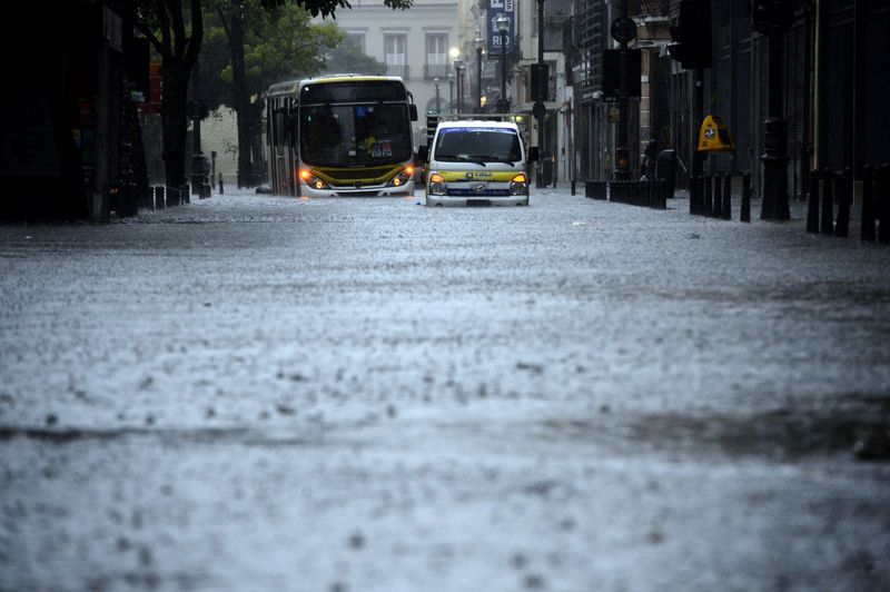 Passageiros de um ônibus ficaram ilhados no alagamento na Rua do Lavradio, na Lapa, região central, durante temporal com forte chuva e vento