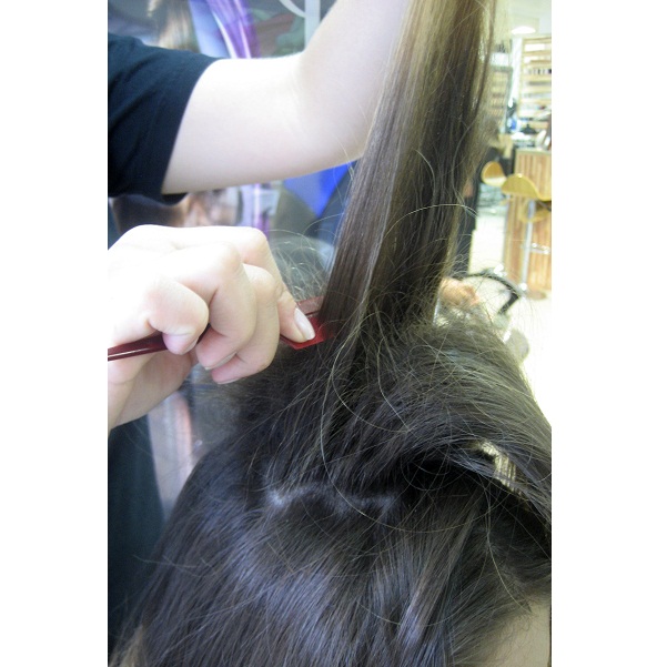 Separe uma parte do cabelo no alto da cabeça e comece a desfiar com a ajuda de um pente fino.<br>