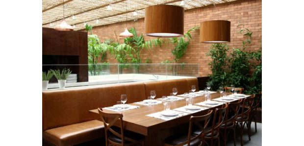 O jardim interno e as grandes mesas de madeira do restaurante tornam o ambiente aconchegante, perfeito para reuniões menores<br>