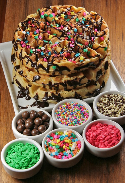 O waffle explosion (R$ 26,90) transforma o lanche em festa. A massa fofinha vemm acompanhada por diferentes opções de calda (chocolate preto, chocolate branco, entre outras) e diversos toppings (granulados, bolinhas brancas e pretas, estrelinhas, corações<br>