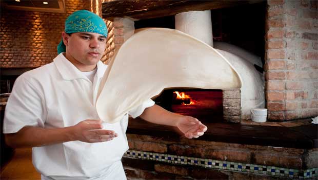 O pizzaiolo Rones Carvalho Alves abre a massa<br>