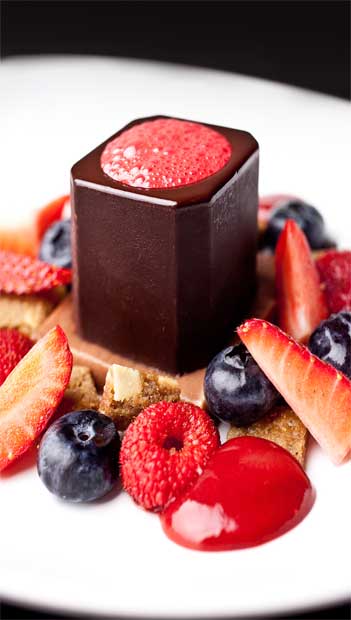 Chocolate amargo, sabayon de framboesa, fondant de avelã e frutas vermelhas<br>