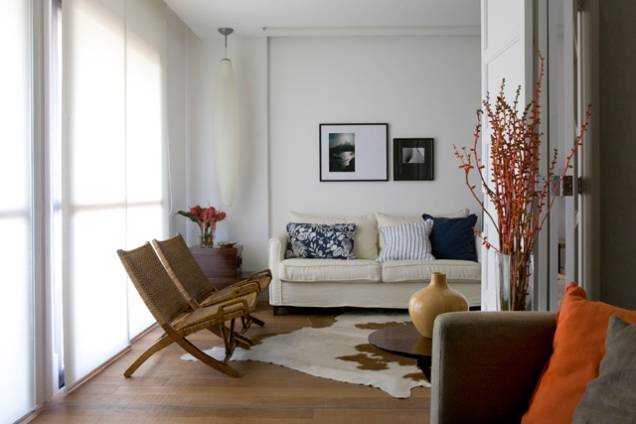 Tecidos coloridos, cortina branca leve e mesas laterais da designer Cândida Interni dão o ar sofisticado a esta bela sala.<br>