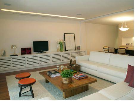 Bancos curingas, flores naturais e tecidos coloridos comp&otilde;em esta sala<br>