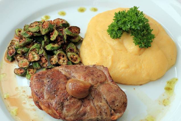 Noix suíno, polenta cremosa, alho assado e quiabo crocante. R$ 59,00.<br> Noix suíno, polenta cremosa, alho assado e quiabo crocante. R$ 59,00.<br>