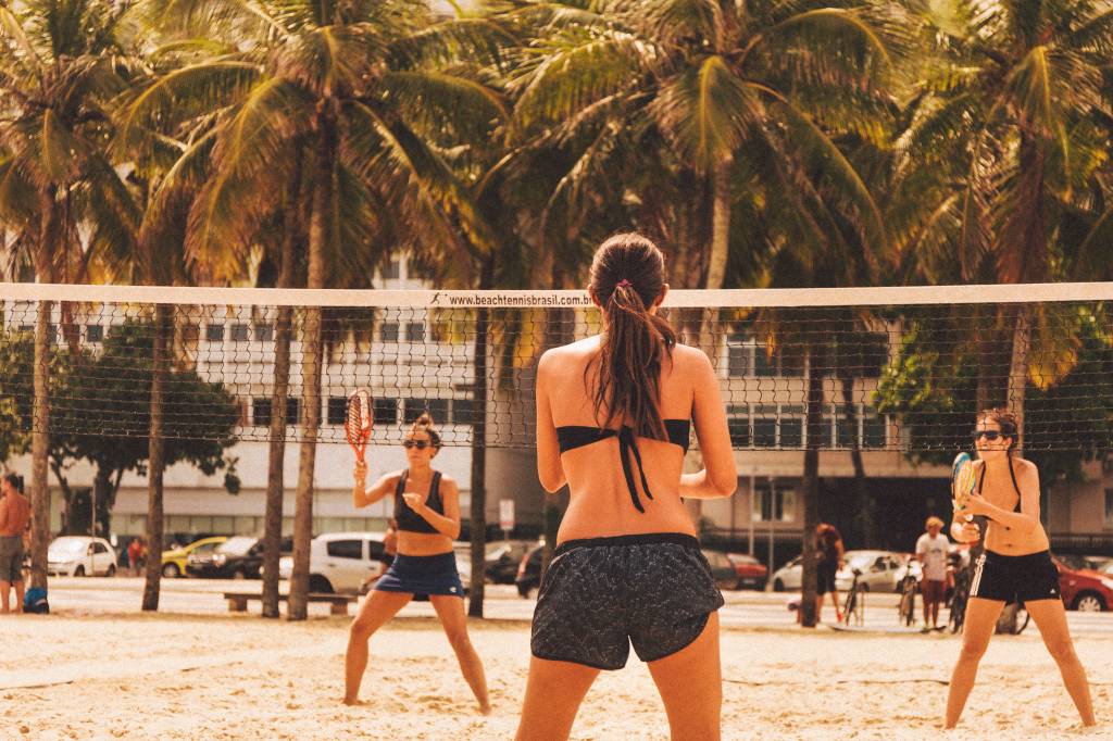 Imagem mostra duas mulheres jogando tênis de praia