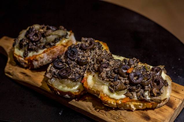 Bruschetta de cogumelo, queijo brie, fondue de tomate, azeitonas e cebola caramelada