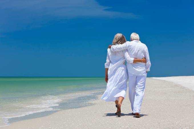 Rear view of senior couple walking on beach