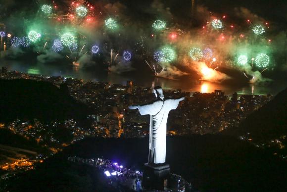 A imagem mostra a queima de fogos no Rio, com o Cristo Redentor em primeiro plano
