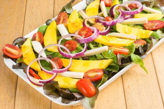 Salada de manga, palmito, passas, rúcula, cebola-roxa e alface com molho de laranja e gengibre Salada de manga, palmito, passas, rúcula, cebola-roxa e alface com molho de laranja e gengibre