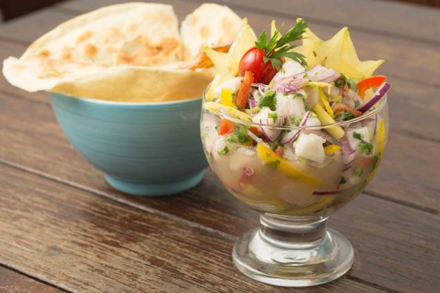 Ceviche de peixe branco com manga, carambola e cebola-roxa ladeado por pizza branca