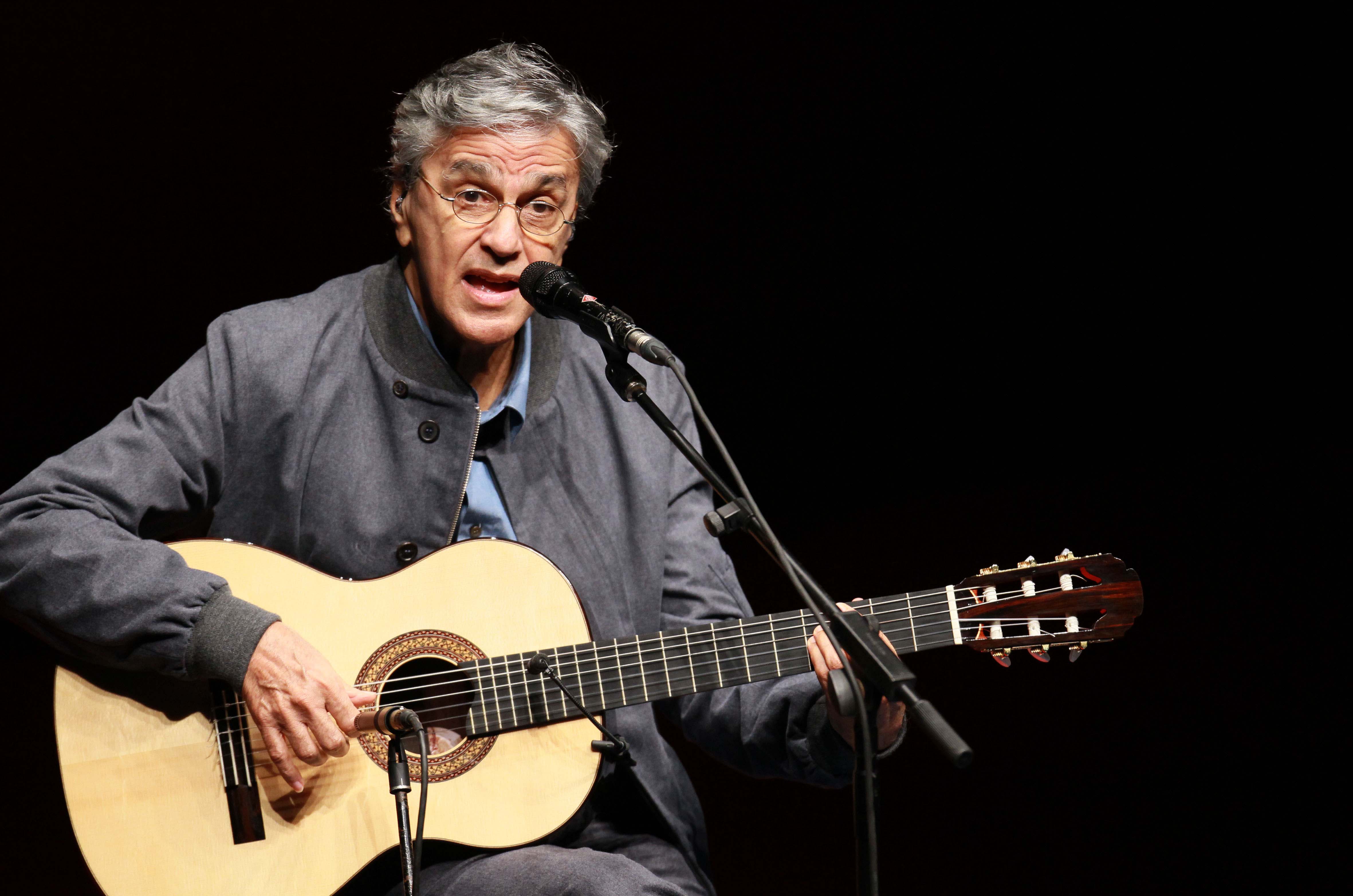 Caetano Veloso, no palco, empunhando o violão