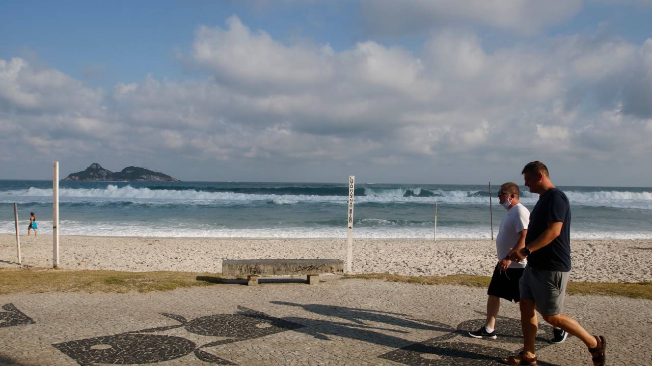 Pessoas andando no calçadão da praia