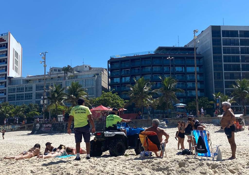 A magem mostra Policiais Militares, de quadriciclo, fiscalizando as areias de Ipanema, onde há pesosas pegando sol durante o período de isolamento