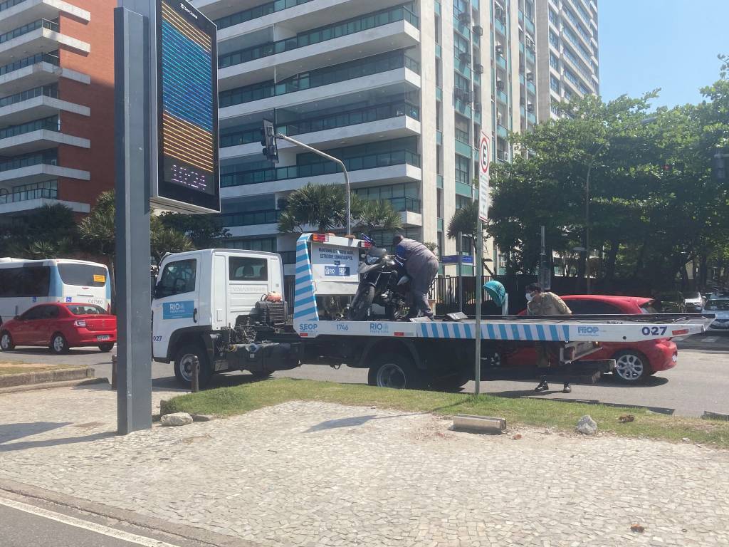 A imagem mostra um carro-reboque da prefeitura em ação, na Praia de Ipanema