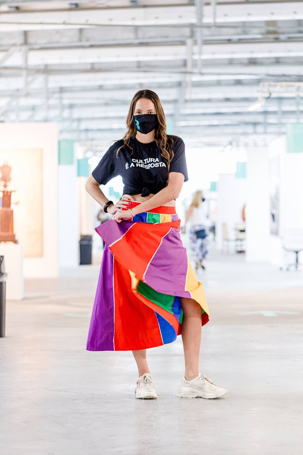 Brenda Valansi, de roupa colorida e máscara facial, na ArtRio de 2020