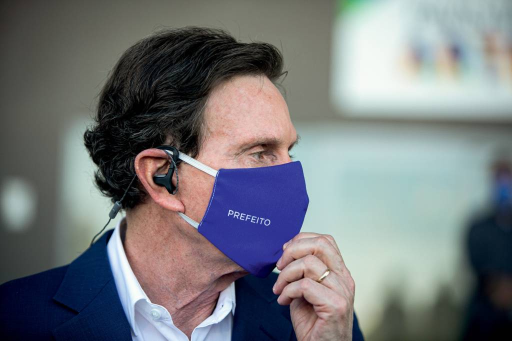 A imagem mostra o prefeito do Rio, Marcelo Crivella, de perfil, usando máscara de proteção azul