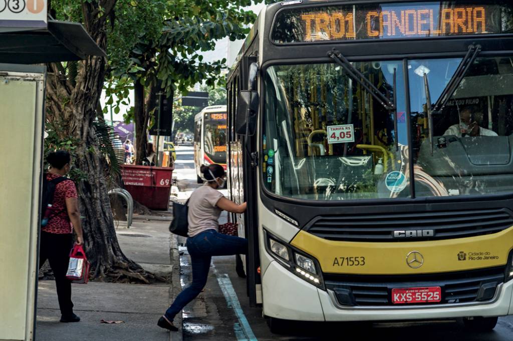 A imagem mostra um ônibus com uma passageira subindo seus degraus