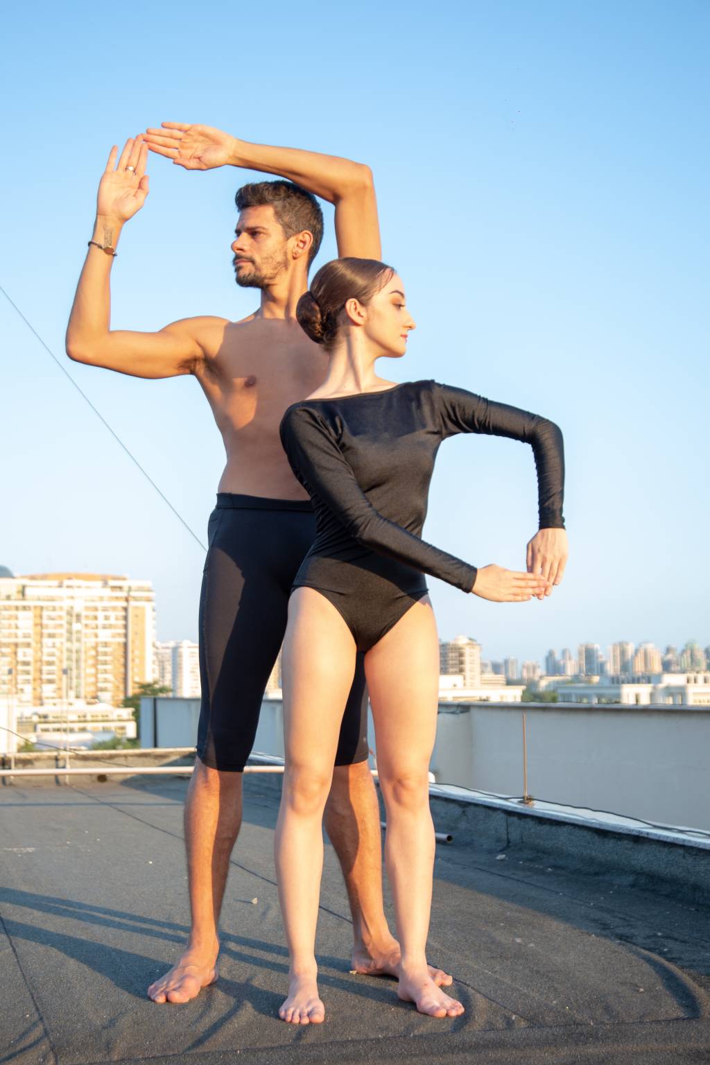 Bailarino Thiago Soares e bailarina Ana Letícia Godoy fazem movimentos com as mãos num espaço ao ar livre