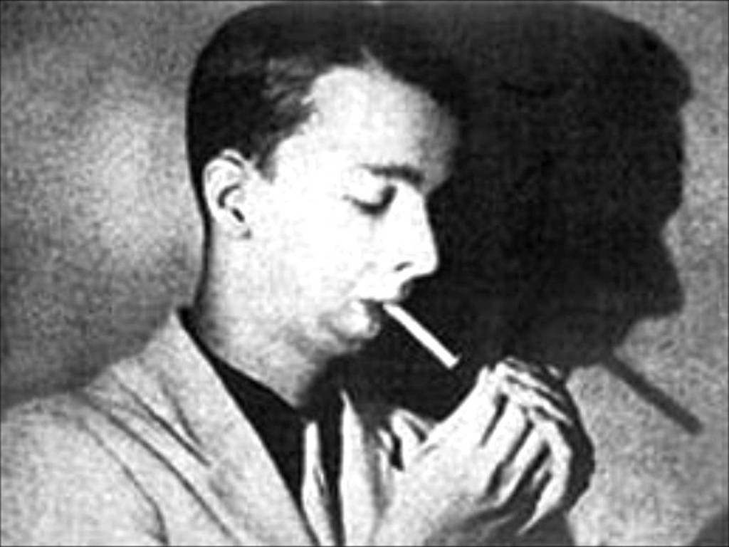 Noel Rosa de perfil, acendendo um cigarro. Foto em preto e branco