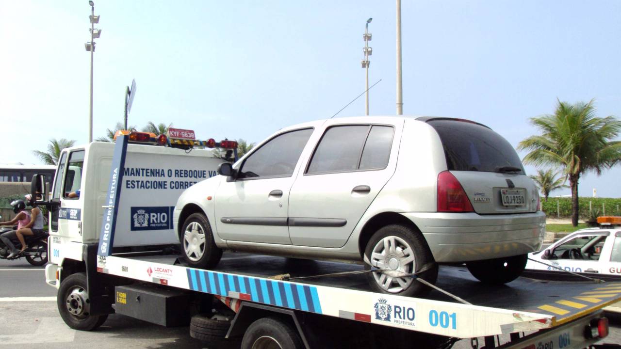 A imagem mostra um carro-reboque da prefeitura em ação