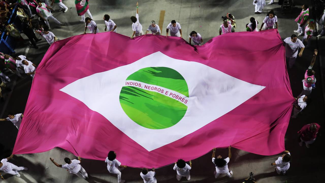 Desfile da Mangueira em 2019, em que integrantes desfilaram sob bandeira do Brasil em verde e rosa com os dizeres índios, negros e pobres