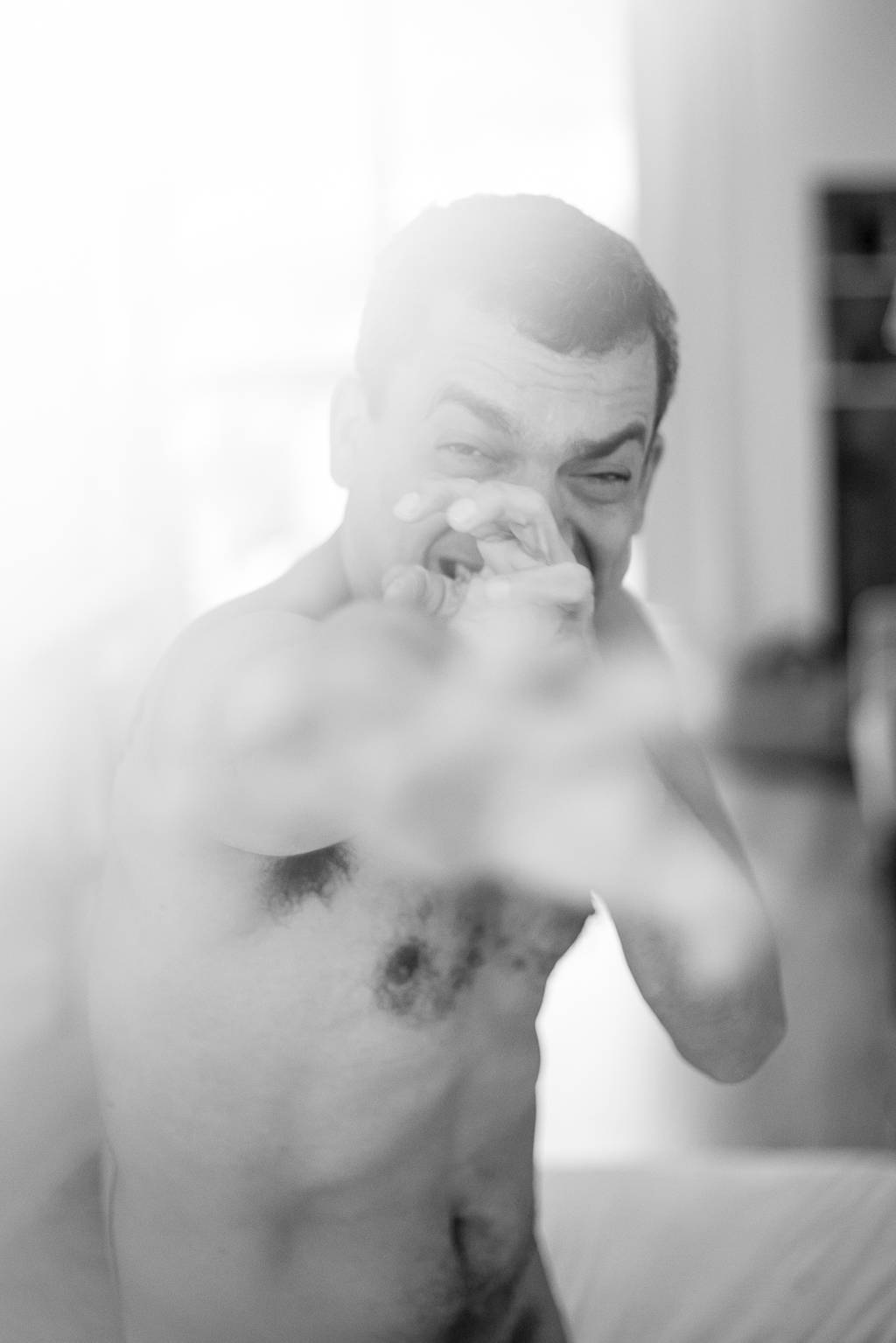 Alexandre Lino com as mãos na frente do rosto, em foto em preto e branco