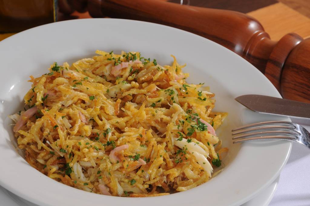 bacalhau desfiado com presunto e temperos em louça branca