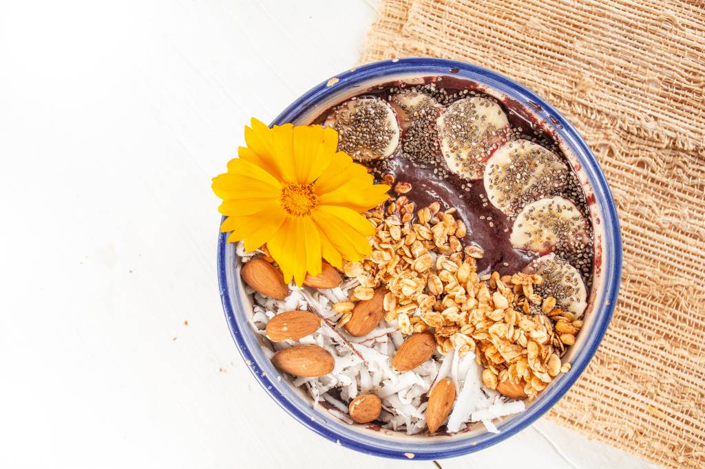 açaí coberto de fatias de banana, raspas de coco fresco, granola, amêndoas e chia