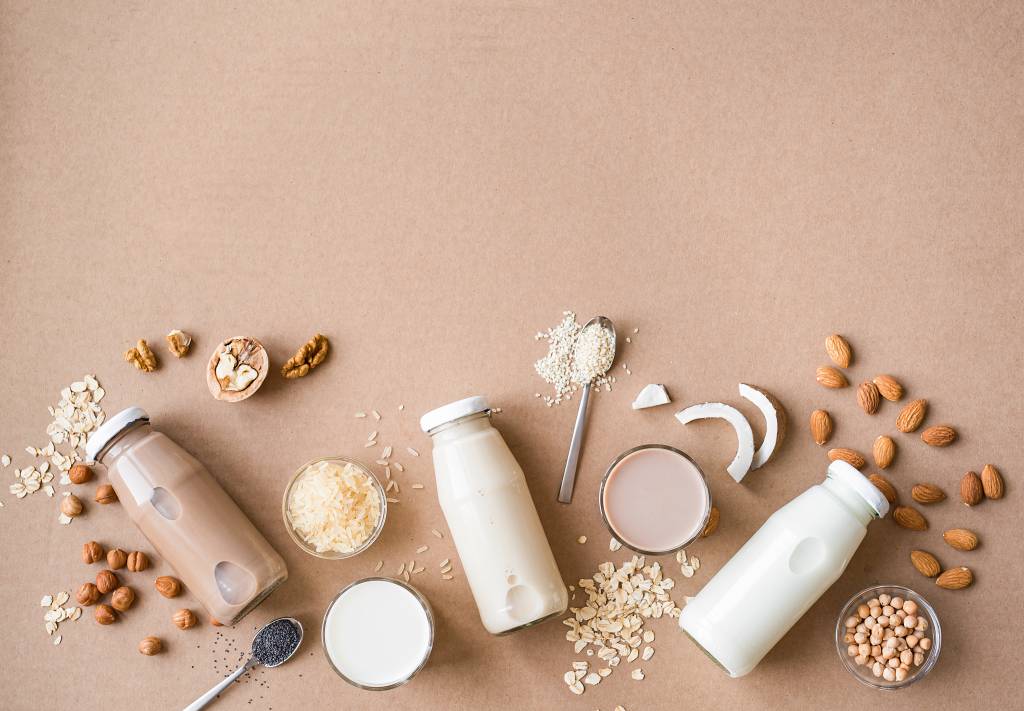 A imagem mostra uma variedade de grãos e garrafas de leite
