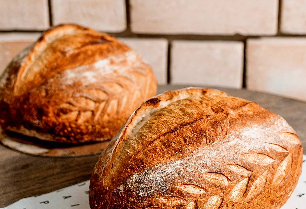 A imagem mostra dois pães de fermentação natural