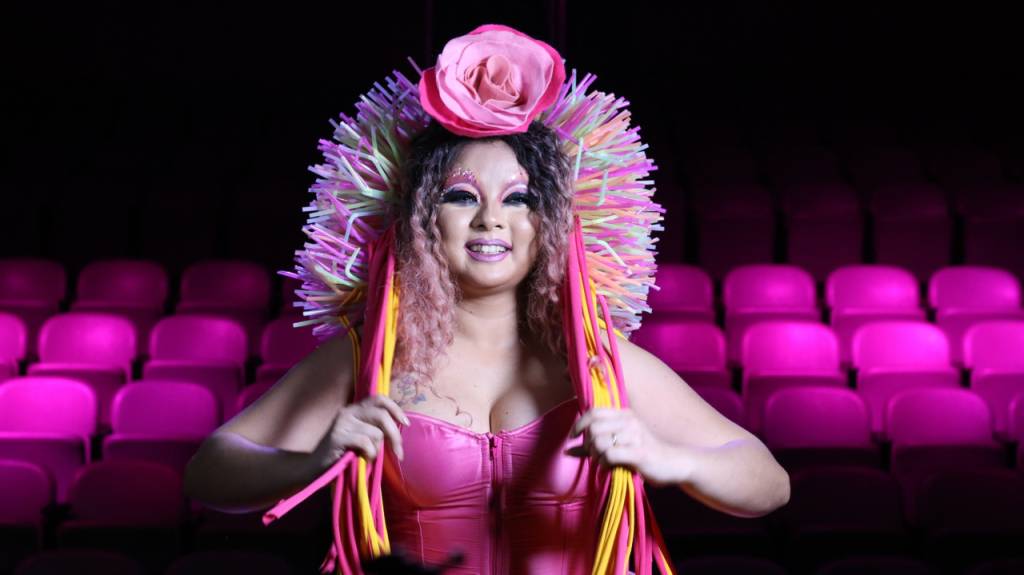 drag queen vestida de roupa rosa num cinema