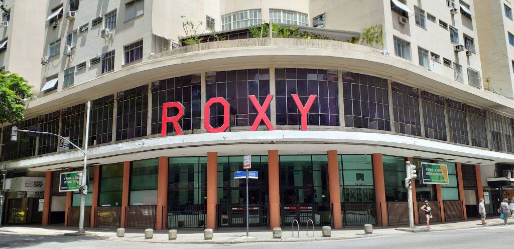 A imagem mostra a fachada do cinema Roxy, com pilastras e grande letreiro