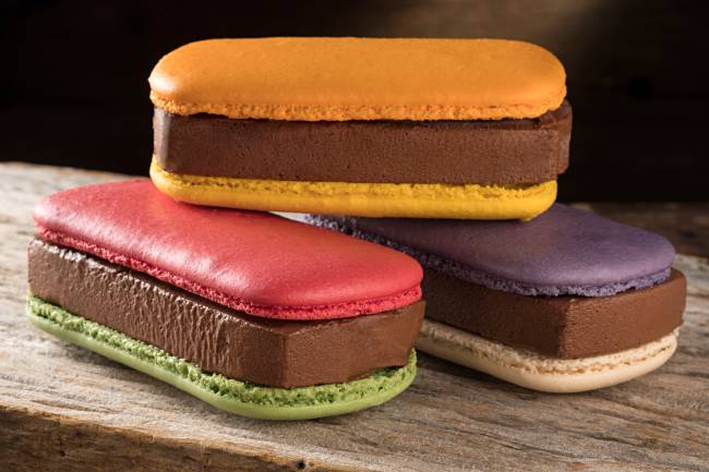 A imagem mostra três sanduíches coloridos com macaron e recheio de sorvete