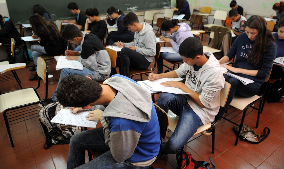 Estudantes fazendo prova em sala de aula.