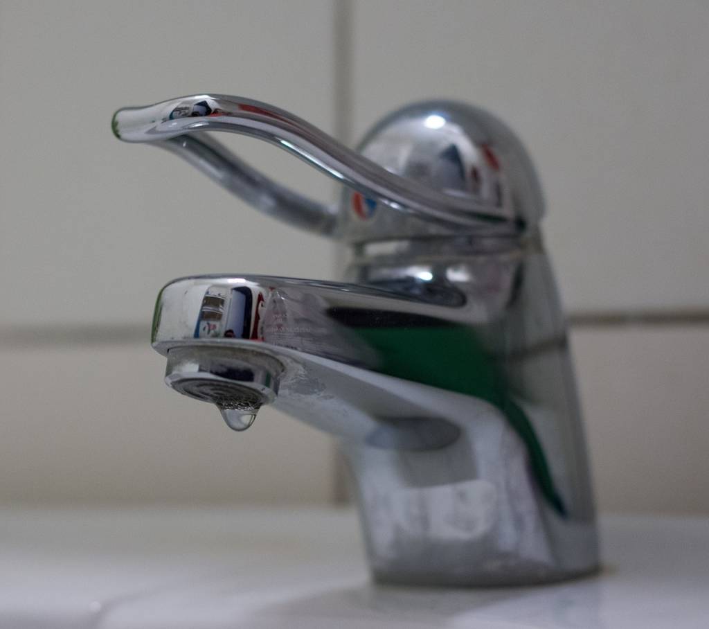 A imagem mostra uma torneira pingando água