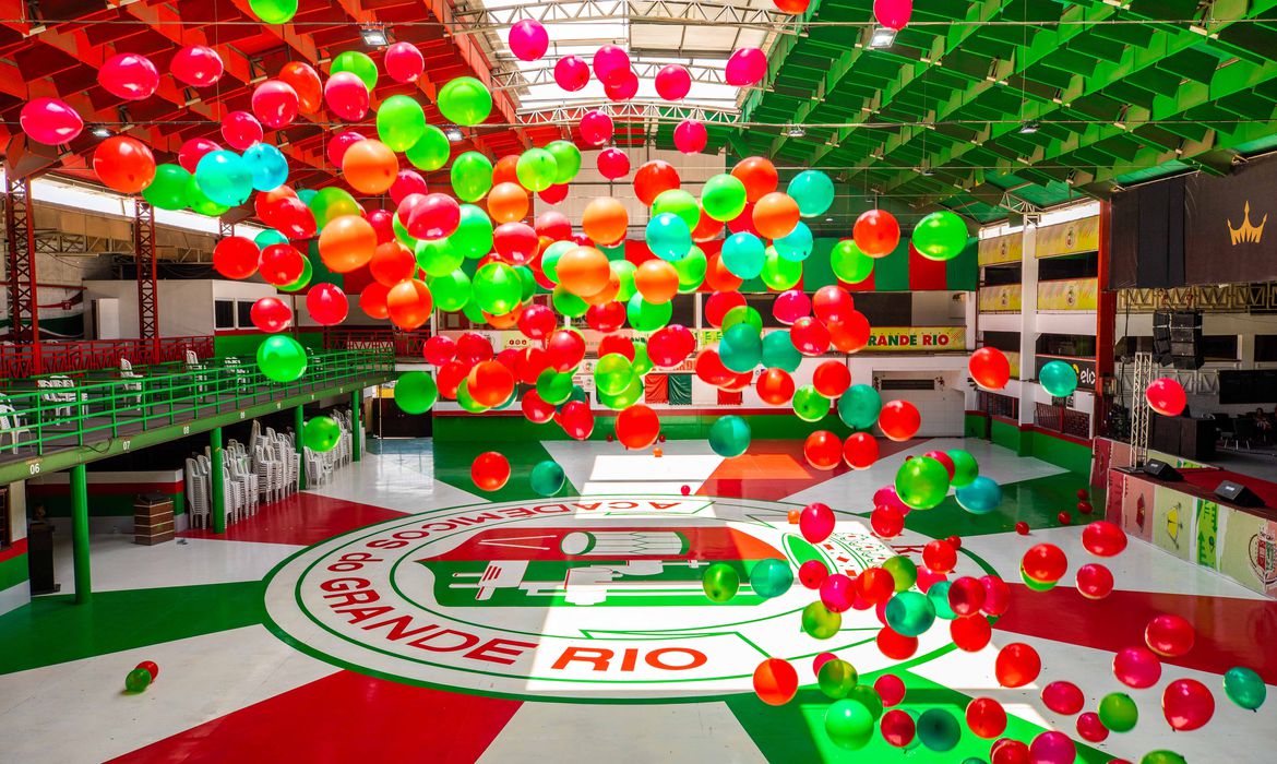 Salão preenchido com balões coloridos verde e vermelho