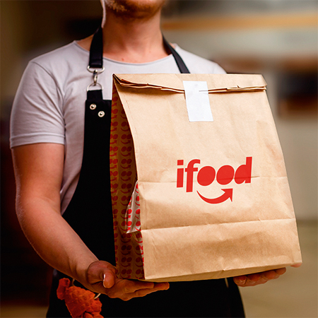 pessoa segurando uma embalagem de entrega do iFood