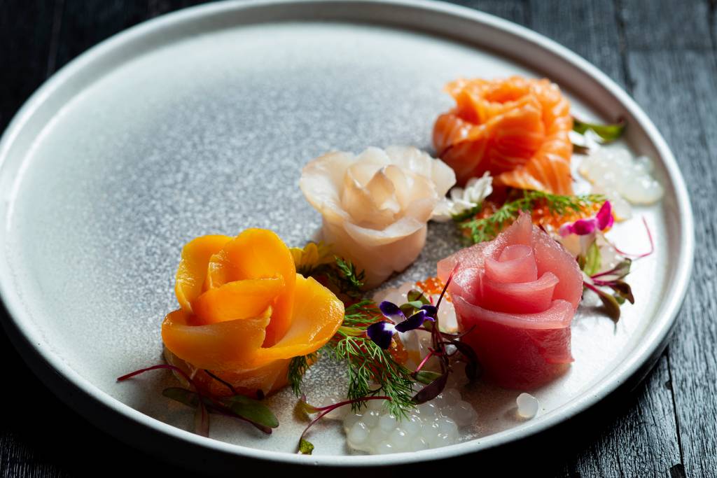 A imagem mostra uma seleção de sashimis em forma de flor