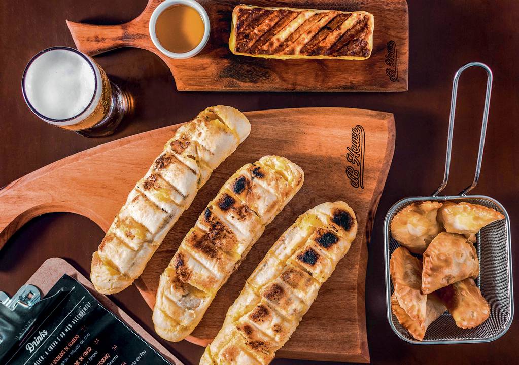 tábua com pães, queijo de coalho e pastéis