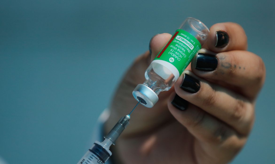 A imagem mostra uma vacina a ser aplicada