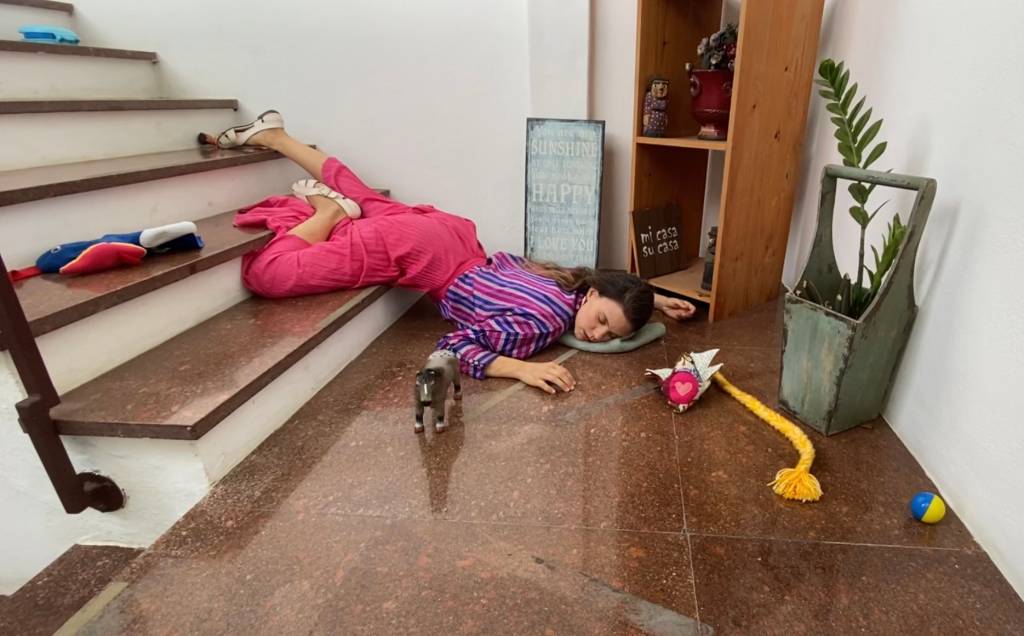 Isadora Medella 01 Isadora Medella caída numa escada, com brinquedos espalhados ao redor