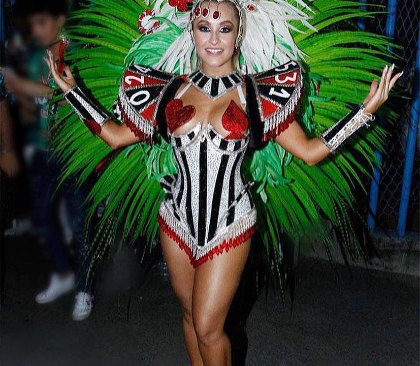 A imagem mostra a atriz Carla Diaz com a fantasia de uma das alas da escola de samba Grande Rio