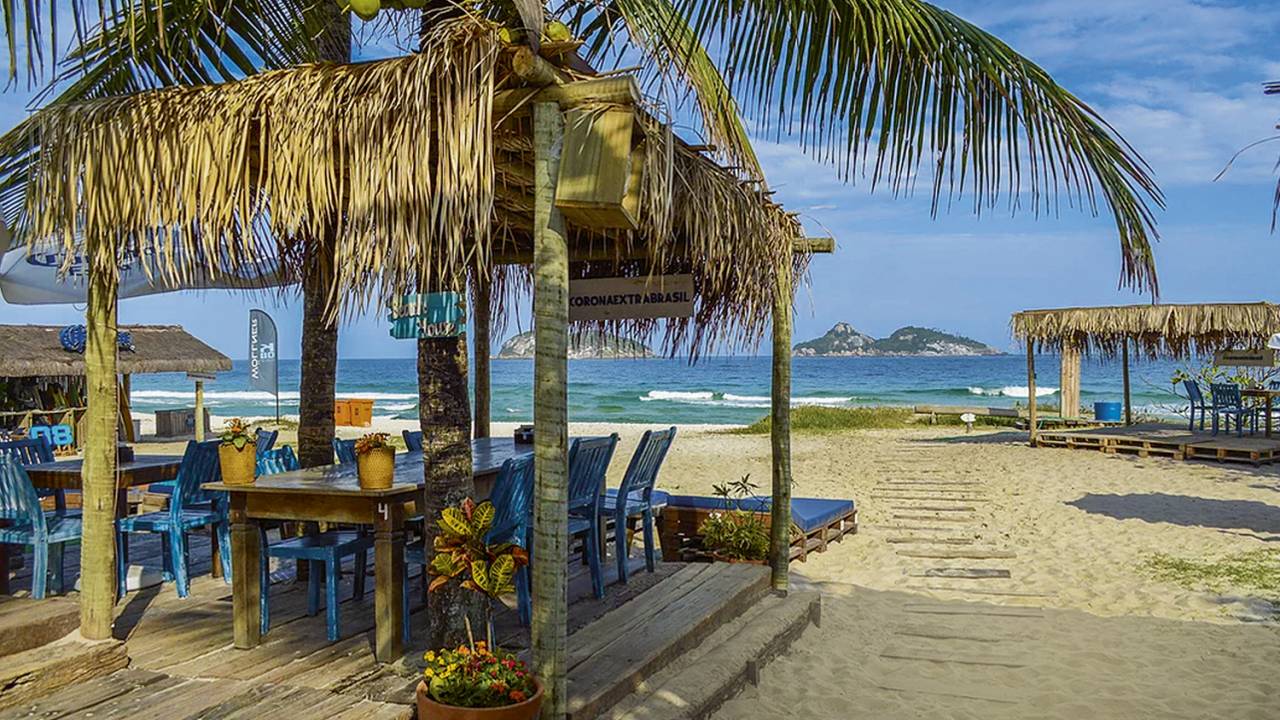 A imagem mostra as mesas e cadeiras azuis do quiosque k08, na Barra