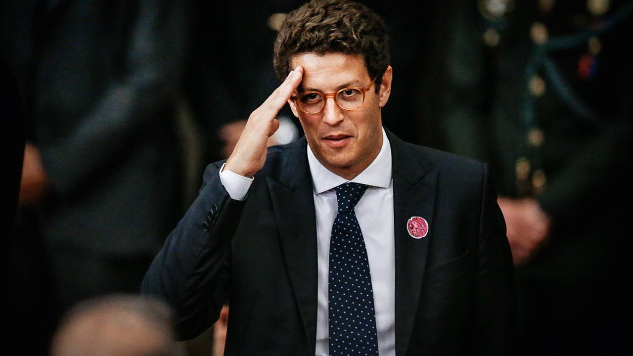 A imagem mostra o ministro do Meio Ambiente, Ricardo Salles, de terno, batendo continência