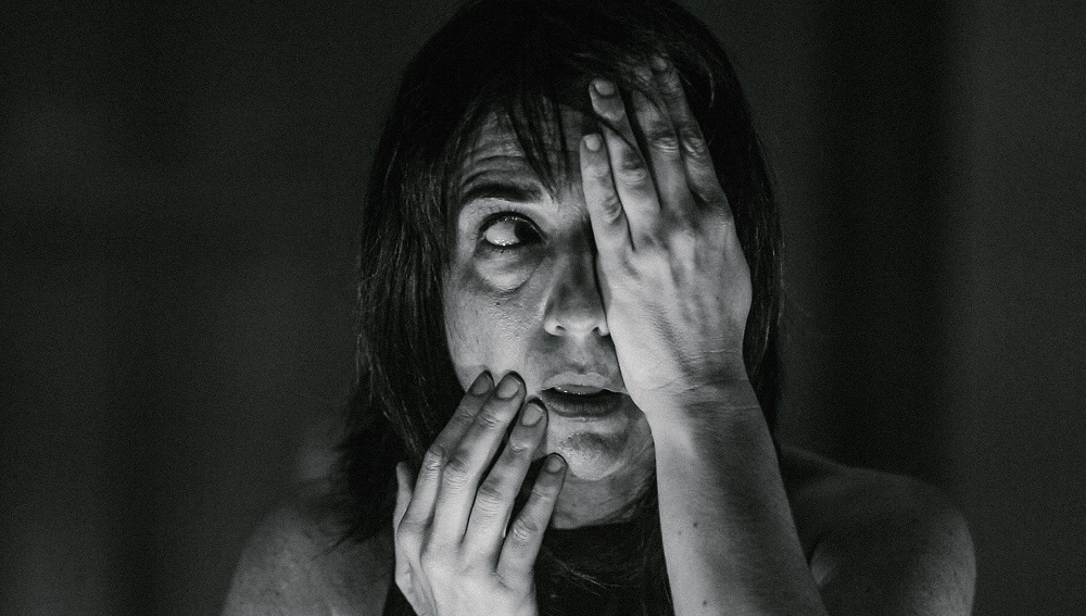 baixa Cena olhos – credito Rodrigo Menezes Atriz com as mãos no rosto, tapando um dos olhos