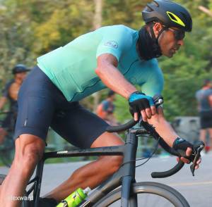 Ciclista faz manobra em pista cercada de verde